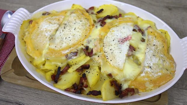 plat de tartiflette au reblochon sur uine table en bois