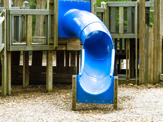 a blue plastic slide in a childrens playground structure