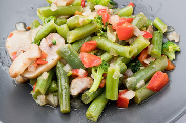 Sautéed vegetables, on a dark plate. In study