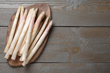 Fresh white asparagus on wooden table, top view. Space for text