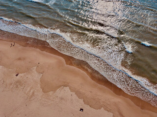 Aerial view of sand beach and top view of sea waves