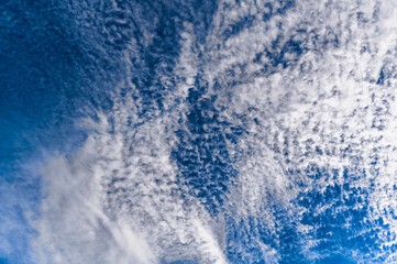Many altocumulus clouds on blue sky.