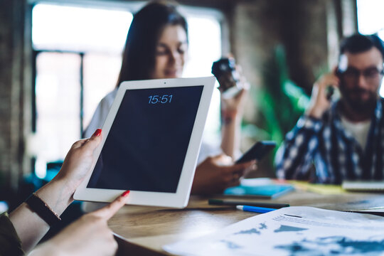 Faceless businesswoman using tablet while working with employees