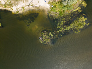 Green banks of a country river. Aerial drone view, sunny summer day.