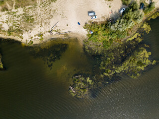 Green banks of a country river. Aerial drone view, sunny summer day.