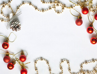 Christmas flat lay, red Christmas balls, pinecone and gold beads on a white background, copy space