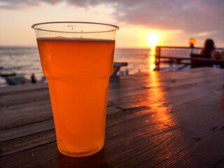 Glass with beer on the table by the sea