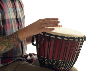 Man plays ethnic drum darbuka percussion, close up musician isolated on white studio background. Male hands tapping djembe, bongo in rhythm. Musical handmade instruments, world culture sound.