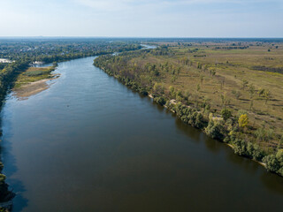 Aerial drone view. The bend of a wide river among green meadows. Sunny summer day.