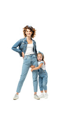 daughter in denim outfit hugging mother leg isolated on white