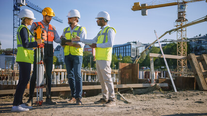 Diverse Team of Specialists Use Tablet Computer on Construction Site. Real Estate Building Project...