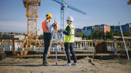 Construction Worker Using Theodolite Surveying Optical Instrument for Measuring Angles in...