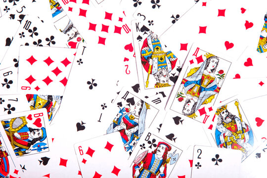 Playing cards are scattered on table. Background of scattered deck of cards filling entire space of image. Top view, close-up. Copyright space for site or logo