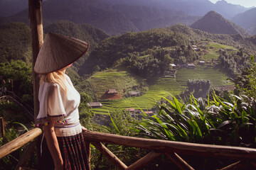 a young European lady dons a traditional Vietnamese hat, immersing herself in the rich cultural...