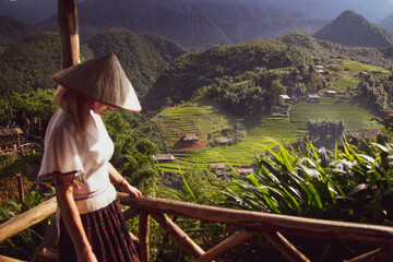 a young European lady dons a traditional Vietnamese hat, immersing herself in the rich cultural...