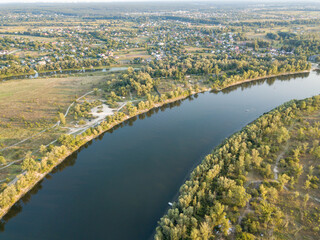 Aerial drone view. The bend of a wide river among green meadows. Sunny summer day.