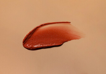 Smear brown lipstick texture smudged isolated on beige  background