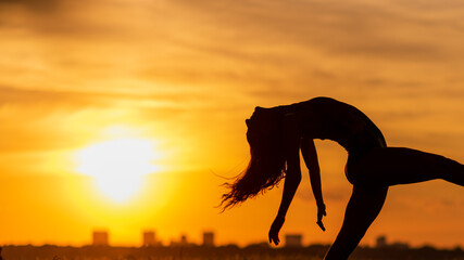 silhouette of ballet dancer at sunset