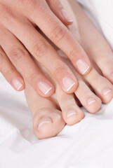 Obraz na płótnie Canvas Close-up of a woman's hand touching her feet