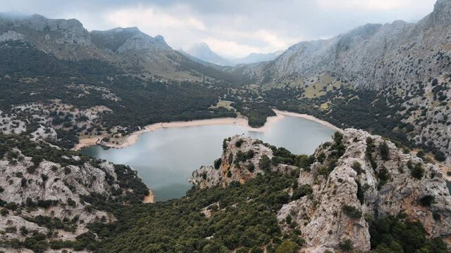 Aerial establishing shot of the Gorg Blau, an artificial reservoir surrounded by Tramuntana mountains in Mallorca