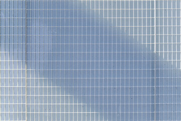 The metal grid on a concrete wall.