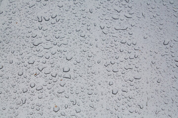 Rainy drops on glass surface. Liquid droplets shape background. Raindrops on window. Autumn weather concept, copy space