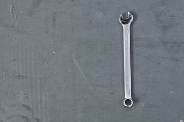 wrench on a gray painted wood surface. metal tools for manual work