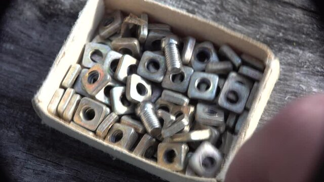 finger looking nuts and screws in Matchbox Various metal details cardboard box