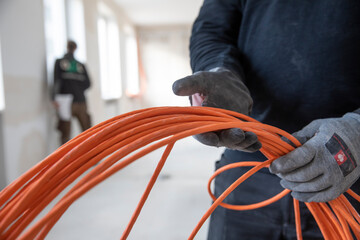 Arbeiter verlegen Kabel auf einer Baustelle, Büroimmobilie, - obrazy, fototapety, plakaty