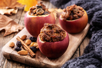 Stuffed apples baked with nuts on wooden table.