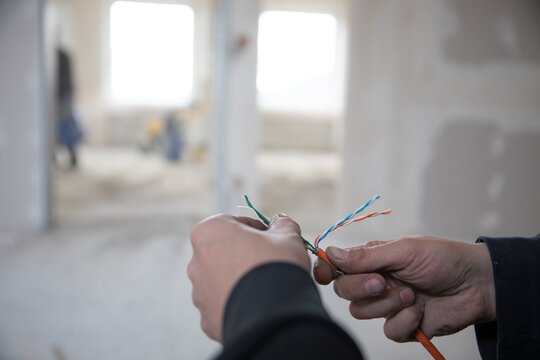 Arbeiter verlegen Kabel auf einer Baustelle, Büroimmobilie,