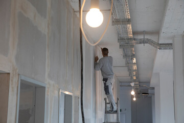 Handwerker glättet die Wände auf einer Baustelle