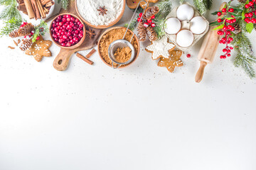 Ingredients for Christmas cooking, winter baking cookies, gingerbread, fruitcake, seasonal drinks. Cranberries, dried oranges, cinnamon, spices, flour on white table, copy space top view