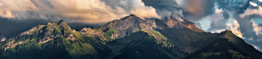 Terrible lifeless rocks, a glacier in the Alps, clouds and fog spread over the peaks of the mountains