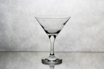 In a Martini glass, standing on a white background, the drink is poured from above