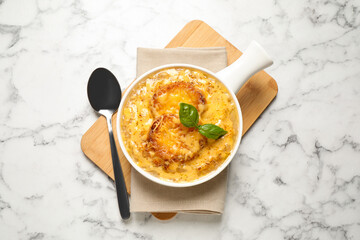 Tasty homemade french onion soup served on white marble table, flat lay