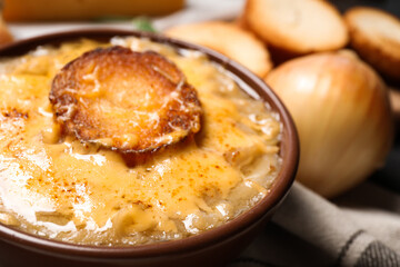 Tasty homemade french onion soup served in ceramic bowl, closeup