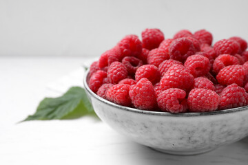 Fototapeta na wymiar Delicious fresh ripe raspberries on white wooden table, closeup