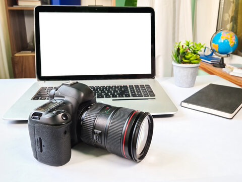 Photographer desk, professional camera with a laptop on the table