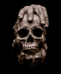 Male hands are holding a dummy human skull on a black background. Halloween theme