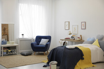Modern teenager's room interior with bed and armchair