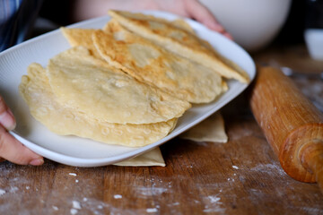 woman prepares a national dish chebureki, chir-chir from unleavened dough stuffed with chopped lamb, minced meat, the concept of traditional cuisine of the peoples of the world