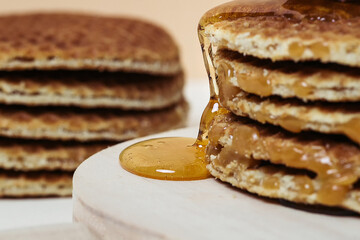 Close-up of honey pouring over some waffles