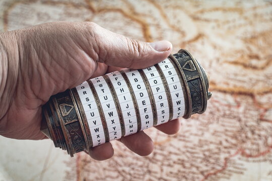 Hand holding a cryptex with a map in the background
