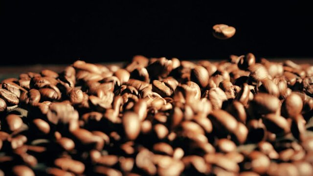 Bouncing coffee beans on a loudspeaker, slow motion close-up shot