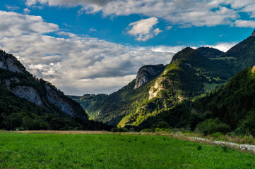 Panoramic view of alpine meadows and rocks in sunset evening lighting