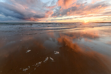 Beautiful sunset at the atlantic Ocean with orange sky.