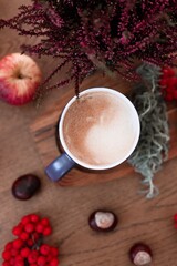 cup of coffee and plants on the wooden background, autumn mood, fall