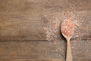 Pink himalayan salt on wooden table, flat lay. Space for text