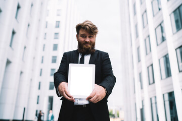 Fototapeta premium Cheerful male entrepreneur with tablet in city